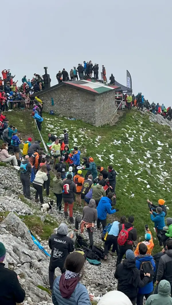 Corredores y público en una cima durante una carrera de montaña